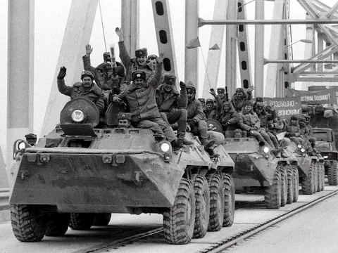 Soldaten auf gepanzerten Fahrzeugen, die eine Brücke überqueren.