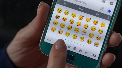 Handybildschirm, der Emojis von einem Nachrichtendienst zeigt.