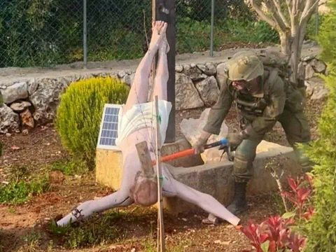 Israelischer Soldat beschädigt Jesus-Figur im Libanon und schlägt mit einem Hammer darauf.