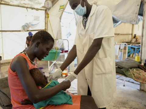 Eine Mutter hält ihren unterernährten Säugling auf dem Schoss. Er wird in einem Spital in Südsudan gepflegt. 