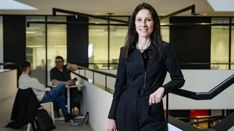 Frau in schwarzer Kleidung in modernem Büro.