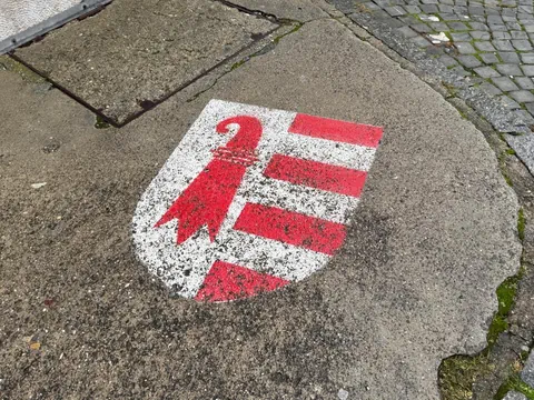 Wappen des Kantons Jura auf der Strasse aufgemalt.