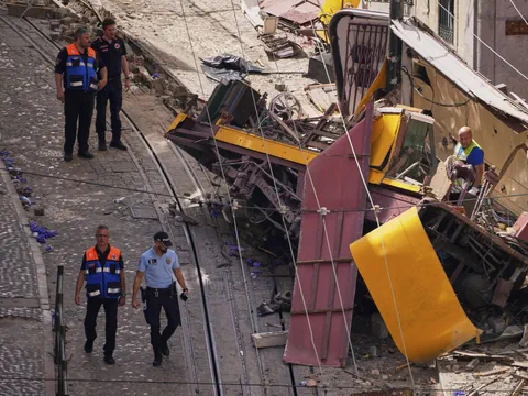 Einsatzkräfte bei zerstörtem gelbem Strassenbahnwrack.