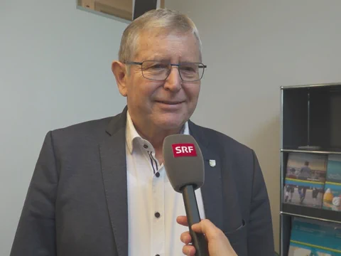 Älterer Mann in Anzug wird mit SRF-Mikrofon interviewt.