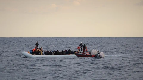 Migranten mit Schwimmwesten auf einem Schlauchboot