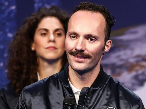 Marco Sieber auf einer Bühne mit Mikrofon. Er lächelt leicht.