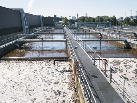 Kläranlage mit Becken und Schaum auf dem Wasser.