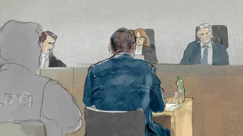 Gerichtssaal mit mehreren Personen, darunter ein Polizist und Richter.