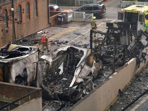 Zerstörte Fahrzeuge und Feuerwehrmann nach Brand in Hof.