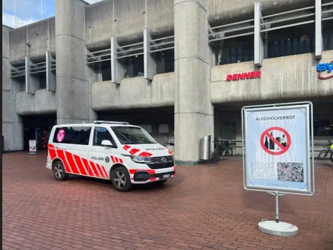 Polizeiwagen vor einem Gebäude mit Alkoholverbotschild.