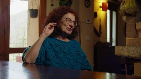 Frau mit blauem Pullover an Tisch