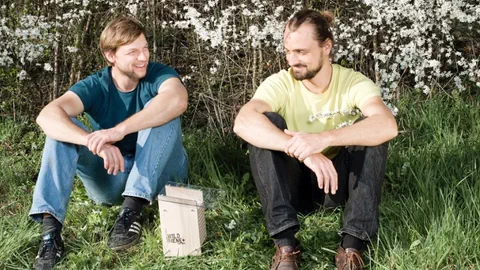 Claudio Sedivy und Thomas Strobl auf einer Wiese mit einem Bienen-Häuschen