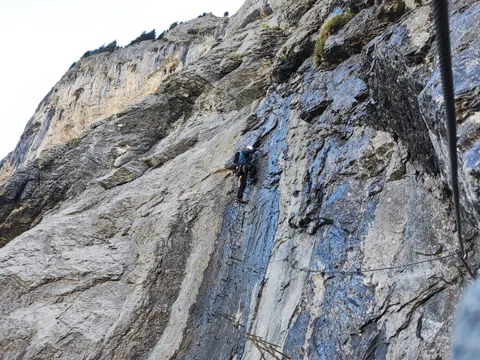 Ein Mann klettert an einer Felswand.