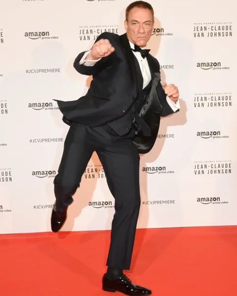 Mann im Anzug in Karate-Pose auf dem roten Teppich.