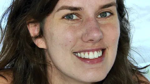 Eine lachende junge Frau mit langem Haar. 