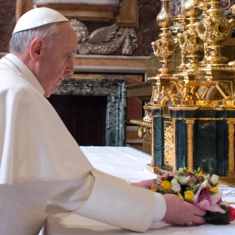 Papst Franziskus legt einen Blumenkranz in einer Kirche ab