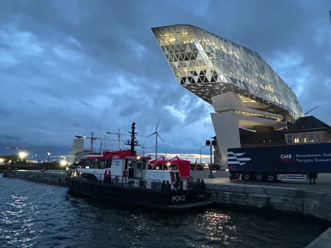 Hafenhaus mit kleinem Schiff und Sattelzug.