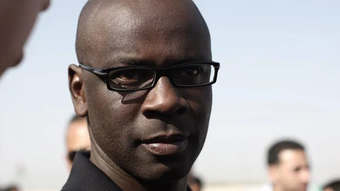 Nahaufnahme des ehemaligen französischen Fussballspielers. Auf dem Bild trägt Thuram eine schwarze Brille, im Hintergrund sind unscharf Teile zweier Gesichter erkennbar.