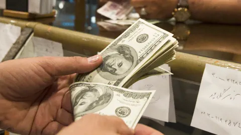 Ein Mann zählt Dollarscheine