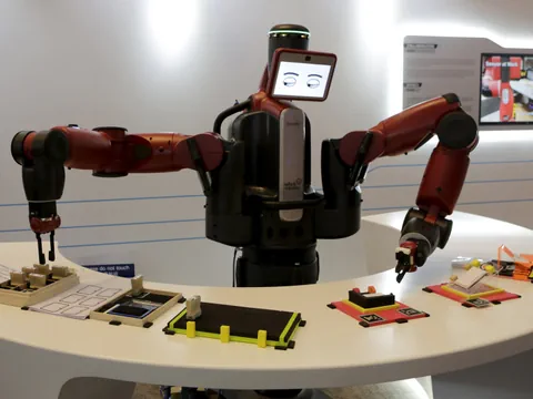 Roboterarm an einem Tisch mit Werkstücken.