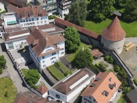 Luftaufnahme von Gebäuden mit roten Dächern und einem runden Turm.