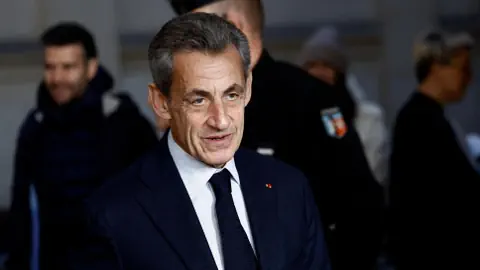 Mann in Anzug bei Veranstaltung in Menschenmenge.