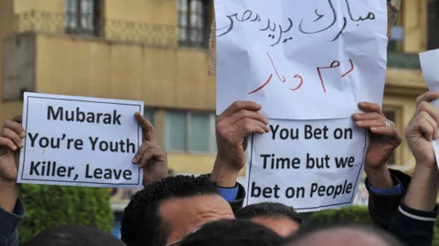 Demonstranten halten Schilder in die Luft