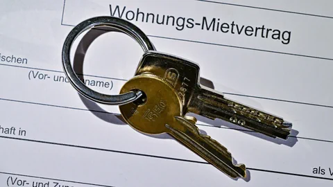 Schlüssel liegt auf einem Mietvertrag. der Vertrag ist nicht ausgefüllt.