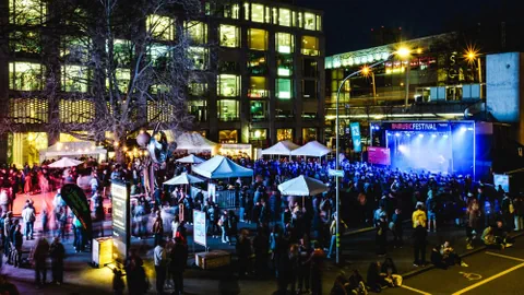 Nachtaufnahme eines Festivals mit Bühne und Menschenmenge.