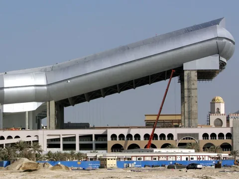 Grosses Gebäude mit schrägem Dach und Palmen im Vordergrund.