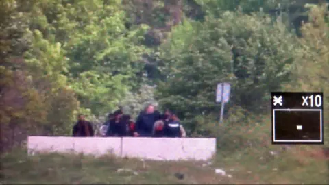 Grenzbeamter mit Gruppe von Flüchtlingen