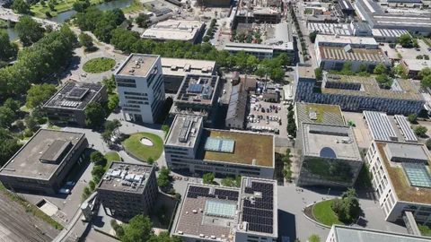 Luftaufnahme eines modernen Stadtcampus mit Gebäuden und Grünflächen.