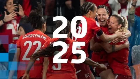 Frauen-Fussballteam in roten Trikots jubelt, Nummern 2025 überlagern Bild.