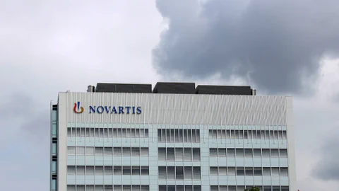 Gebäude mit Novartis-Logo unter bewölktem Himmel.