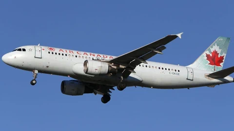 Air Canada Flugzeug im Flug vor blauem Himmel.