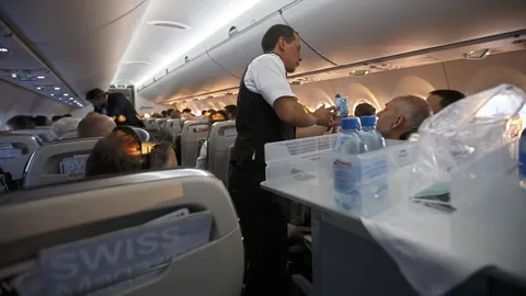 Flugbegleiter bedient die Passagiere während eines Fluges.