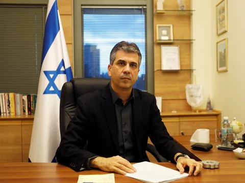 Mann in Büro mit israelischer Flagge am Schreibtisch.