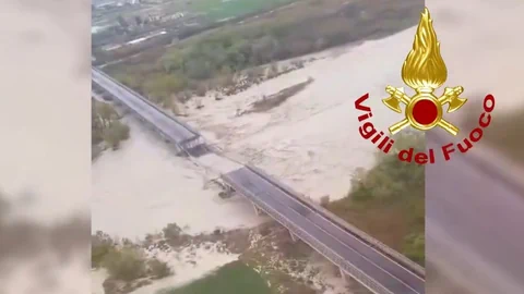 Luftaufnahme einer überfluteten Brücke, Vigili del Fuoco-Logo.