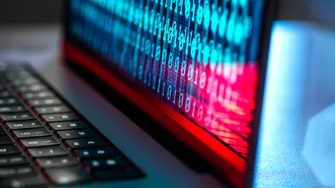 Laptop mit digitalem Binärcode auf Bildschirm.