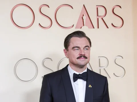 Mann im Anzug bei Oscar-Veranstaltungshintergrund.