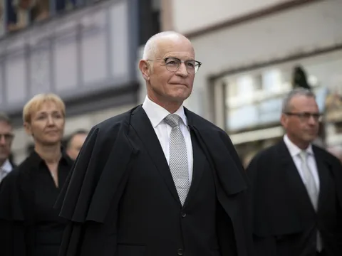 Gruppe von Menschen in formeller Kleidung bei einer Veranstaltung.