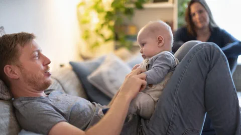 Vater mit Kind, dahinter die Mutter.