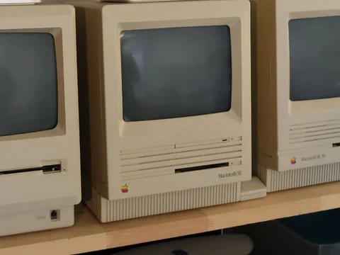 Alte Macintosh-Computer auf einem Regal.