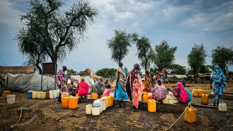 Frauen mit gelben Kanister beim Wasserholen bei einem Brunnen in Darfur. 