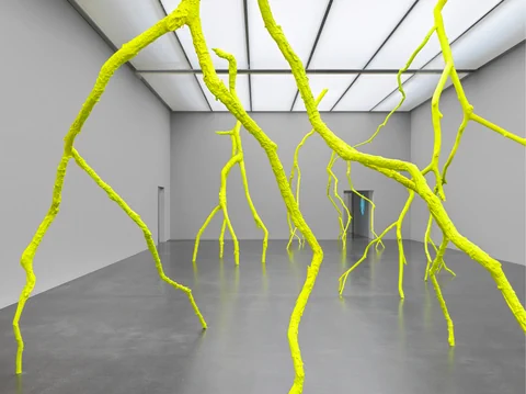 Neongelbe Skulpturen in modernem Ausstellungsraum.