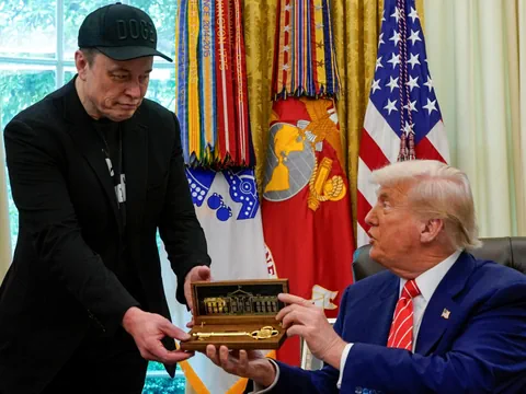Trump übergibt Musk einen goldenen Schlüssel.