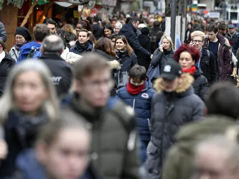Menschenmenge auf belebter Strasse im Winter.