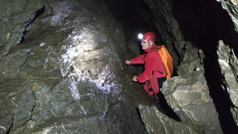 Mann in einer engen Höhle.