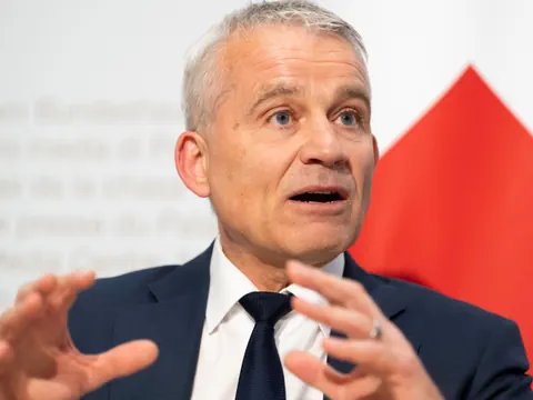 Ein Mann in einem Anzug gestikuliert während er spricht.