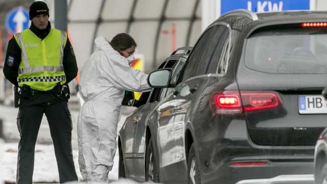 Eine Ärztin kontrolliert die Temperatur eines Autofahrers an einem Grenzübergang. Eine Ärztin kontrolliert die Temperatur eines Autofahrers an einem Grenzübergang.